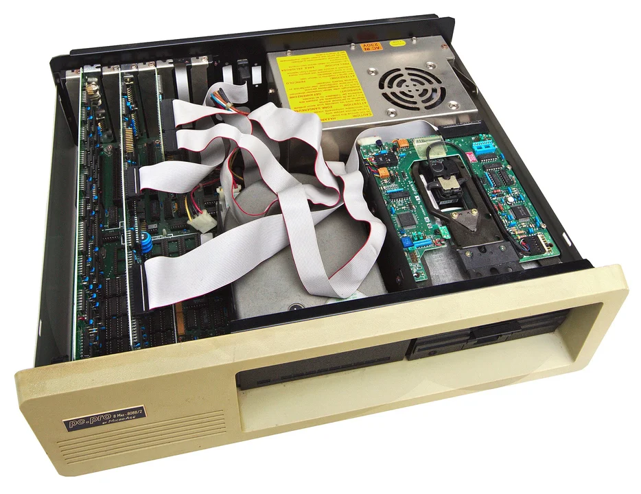 Inside a beige PC tower from the early 1990s, showing expansion cards and disk drives
