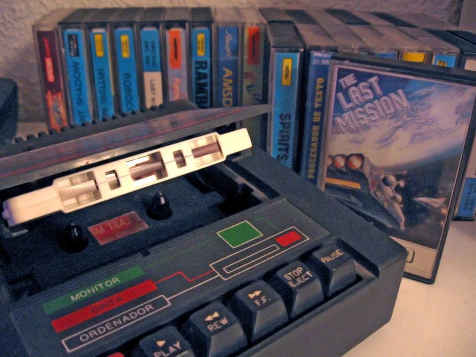 The CPC 464 built-in cassette deck, open, with a shelf of game tapes behind it